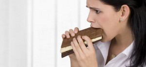 mujer comiendo una tableta de chocolate 