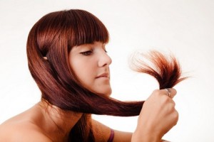 mujer mirándose las puntas del cabello 