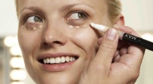 mujer usando un maquillaje para cubrir las ojeras 