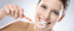 mujer cepillando los dientes para lograr una sonrisa perfecta